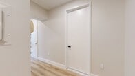Located at 95 Wall Street, Unit 1823 in the heart of Lower Manhattan, this 400-square-foot studio offers a well-designed single-floor layout comprising a combined kitchen and living area, a closet, and a full bathroom. Light hardwood flooring runs throughout the unit, lending a clean, contemporary aesthetic. The open kitchen is outfitted with dark wood cabinetry featuring matte black hardware, white quartz countertops, and a full suite of stainless steel appliances including a gas range, built-in microwave, dishwasher, and refrigerator — providing a highly functional cooking space. The living area is bathed in natural light from floor-to-ceiling windows framed in dark metal, offering direct views of the surrounding Manhattan skyline. Wall-mounted HVAC units provide individualized climate control. The bathroom showcases Carrara marble-style tile flooring and wall detailing, paired with matte black fixtures and a recessed mirror cabinet, creating a refined and modern finish. Neutral walls and recessed lighting throughout contribute to a bright, airy atmosphere, maximizing the sense of space within this efficiently designed urban studio.