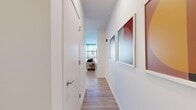 Located at 741 N Wells St in Chicago's vibrant River North neighborhood, this modern one-bedroom, one-bathroom residence offers a thoughtfully designed layout with high-end finishes throughout. Light wood flooring flows seamlessly across the entire space, complemented by crisp white walls that enhance the bright, airy atmosphere.

A welcoming entry hallway adorned with framed artwork leads into the open-plan kitchen and living area. The kitchen is a standout feature, boasting sleek high-gloss cabinetry in a two-tone palette, a white textured tile backsplash, stainless steel appliances including a gas range, and a central island with seating — ideal for both cooking and casual dining.

The living room is bathed in natural light from expansive floor-to-ceiling windows and a glass door opening to a balcony, offering stunning Chicago skyline views. The bedroom continues the floor-to-ceiling window theme, framing dramatic city and skyline vistas that make a striking architectural statement.

The bathroom features a warm wood vanity with a white countertop, a backlit mirror, and a glass-enclosed shower, all set against a clean, all-white backdrop for a spa-like feel. This residence combines contemporary urban design with abundant natural light and sweeping city views.