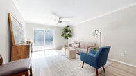 This single-story, 2-bedroom, 2-bathroom residence in Birmingham, Alabama offers a thoughtfully designed layout with a clean, modern aesthetic throughout. The living area is bright and welcoming, featuring light hardwood-style flooring, crown molding, and a ceiling fan. A large sliding glass door floods the space with natural light and opens to a private outdoor patio, creating a seamless indoor-outdoor connection. The living and dining areas flow openly into one another, making the floor plan feel spacious and well-connected. The kitchen is equipped with light maple cabinetry, granite-style countertops, black appliances including a range and refrigerator, and light hardwood-style flooring that ties into the main living areas. A dedicated dining space sits adjacent to the kitchen, providing ample room for a full dining set. Both bedrooms are carpeted and finished in neutral tones, offering a calm and restful atmosphere. The primary bedroom includes an en-suite bathroom and a walk-in closet. The bathrooms feature wood-tone vanities with granite-style countertops and tub-shower combinations. Light hardwood-style flooring continues through the bathrooms, maintaining a cohesive design palette throughout the entire residence.