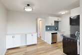 Located at 3009 W 13 Mile Rd in Royal Oak, Michigan, this thoughtfully designed unit offers a clean, modern aesthetic throughout its efficiently organized single-floor layout. Light-toned luxury vinyl plank flooring flows through the open-concept living and dining area, which is bathed in natural light from large windows fitted with blinds. Baseboard heating runs along the perimeter, ensuring comfort year-round. The kitchen is a standout feature, showcasing crisp white cabinetry, a striking blue geometric tile backsplash, light quartz-style countertops, and stainless steel appliances including a dishwasher. Additional white cabinetry along an adjacent wall provides generous storage and counter space. A hallway connects the main living area to the rest of the unit. The bathroom features elegant marble-style wall tile surrounding the tub/shower and is finished with matte black hardware accents. The carpeted bedroom offers a serene retreat with access to a private balcony through a sliding glass door, as well as a wall A/C unit for warm months. Two spacious closets with built-in shelving provide ample storage. A second balcony further extends the outdoor living options. The unit presents a cohesive, freshly updated interior with neutral tones and modern finishes throughout.