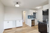 Located at 3009 W 13 Mile Rd in Royal Oak, Michigan, this thoughtfully designed unit offers a clean, modern aesthetic throughout its efficiently organized single-floor layout. Light-toned luxury vinyl plank flooring flows through the open-concept living and dining area, which is bathed in natural light from large windows fitted with blinds. Baseboard heating runs along the perimeter, ensuring comfort year-round. The kitchen is a standout feature, showcasing crisp white cabinetry, a striking blue geometric tile backsplash, light quartz-style countertops, and stainless steel appliances including a dishwasher. Additional white cabinetry along an adjacent wall provides generous storage and counter space. A hallway connects the main living area to the rest of the unit. The bathroom features elegant marble-style wall tile surrounding the tub/shower and is finished with matte black hardware accents. The carpeted bedroom offers a serene retreat with access to a private balcony through a sliding glass door, as well as a wall A/C unit for warm months. Two spacious closets with built-in shelving provide ample storage. A second balcony further extends the outdoor living options. The unit presents a cohesive, freshly updated interior with neutral tones and modern finishes throughout.