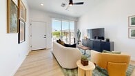 Located at 450 N Apache Rd in Buckeye, Arizona, this thoughtfully designed one-bedroom, one-bathroom home offers a clean, modern aesthetic throughout its single-floor layout. Light wood flooring flows seamlessly across every room, contributing to a cohesive and airy feel.

The open kitchen and living area serves as the heart of the home. The kitchen stands out with impressively soaring ceilings, floor-to-ceiling white cabinetry, a white tile backsplash, stainless steel appliances including a range, microwave, dishwasher, and refrigerator, and a matte black sink fixture. A dining area with a natural wood table sits adjacent, making the space ideal for both cooking and entertaining.

The living room is bright and welcoming, featuring large sliding glass doors that flood the space with natural light and provide direct access to the outdoors. A ceiling fan adds practical comfort to the open layout.

The bedroom is a comfortable retreat with sliding glass door access to the exterior, a ceiling fan, and ample natural light. A dedicated closet and hallway provide practical storage and smooth circulation throughout the home.

The bathroom is clean and functional, featuring a soaking tub with a tiled surround, a shower curtain, a vanity, and consistent light wood flooring that ties the space together with the rest of the home.