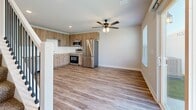 Located in Oak Grove, Missouri, this two-story home offers a well-designed layout spread across two floors, with the main living areas on the lower level and bedrooms above. The ground floor features an open-concept kitchen and living room finished with light wood-look vinyl plank flooring and ceiling fans. The kitchen is equipped with stainless steel appliances, including a refrigerator, range, and microwave, complemented by warm wood-tone cabinetry and clean white countertops. A sliding glass door in the living area brings in natural light and provides outdoor access. An attached garage with an automatic opener offers convenient interior access and additional storage space. Upstairs, the spacious primary bedroom features plush carpet, a ceiling fan, and dual closets. The second bedroom is carpeted as well, with a window that allows in natural light. The home includes five bathrooms, each featuring wood-tone vanity cabinetry, white countertops, and wood-look vinyl flooring. The primary bathroom includes a walk-in glass shower. A staircase with white newel posts and dark metal balusters connects the two floors, adding a modern touch to the interior design. The neutral color palette and consistent finishes throughout create a cohesive and move-in ready environment.