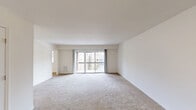 This 2-bedroom, 1-bathroom unit at 1501 Parkside Ave in Trenton, NJ offers a well-organized, single-floor layout with a comfortable sense of space throughout. The living room is the centerpiece of the home, featuring plush wall-to-wall carpeting, neutral white walls, and a large sliding glass door that opens onto a private balcony, flooding the room with natural light and providing outdoor views of the surrounding landscape. The layout flows seamlessly from the living area into the kitchen, which is outfitted with rich dark wood cabinetry, stainless steel appliances including a gas range with oven and over-the-range microwave, a classic tile backsplash, stone-look countertops, and light hardwood-style flooring. Both bedrooms are carpeted and bathed in natural light from wide windows with outdoor views. The generously sized primary bedroom offers ample room for furnishings, while the second bedroom provides a comfortable and functional space. The bathroom features light wood cabinetry with granite-look countertops, a mirrored medicine cabinet, tile flooring, and a linen storage tower. A dedicated closet provides additional storage. The unit maintains a clean, neutral palette throughout, creating a bright and move-in ready living environment.