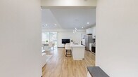 Located at 802 37th Ave NW in Rochester, Minnesota, this well-appointed 2-bedroom, 3-bathroom single-floor residence offers a thoughtfully designed open-concept layout with a clean, modern aesthetic throughout. The living room is a standout feature, boasting vaulted ceilings, light hardwood flooring, a sleek linear fireplace, and multiple windows that fill the space with natural light and views of the surrounding greenery. The kitchen is bright and highly functional, showcasing white shaker cabinetry, a large quartz-topped center island with bar seating, stainless steel appliances, and contemporary sculptural pendant lighting — ideal for both everyday living and entertaining. The bedrooms are carpeted and comfortably sized, with the generously proportioned primary bedroom offering a walk-in closet with built-in shelving and hanging rods. The three bathrooms are finished with light wood-look luxury vinyl flooring and clean white walls, with at least one bathroom featuring accessibility grab bars. A dedicated laundry room houses a full-size side-by-side washer and dryer. The entrance provides a welcoming transition into the home. Throughout, the unit maintains a cohesive neutral palette with dark wood baseboards, creating a warm and polished living environment.