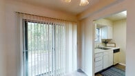 Located at 290 Village Creek Cir in Winston-Salem, NC, this two-floor residence offers a straightforward, functional layout with a mix of flooring materials and natural light throughout. The main living area features durable wood-style flooring, neutral walls, and a textured ceiling, creating a clean and practical space. A large sliding glass door fitted with vertical blinds draws in generous natural light and provides views of the surrounding wooded landscape, giving the main floor a connection to the outdoors.

Adjacent to the living area, the dining space is defined by a classic chandelier and additional vertical blinds that continue the cohesive window treatment style. The kitchen is efficiently laid out with white cabinetry, speckled countertops, a built-in dishwasher, an electric range with overhead ventilation, and a sink positioned near a window for added natural light.

Transitioning to the upper floor, the bedrooms are carpeted and well-lit, with windows that overlook the greenery outside. Each bedroom offers a calm, neutral atmosphere suited for rest. The bathroom includes a full tub and shower combination, wood-style flooring, and clean white fixtures. A hallway area with closet access provides additional storage between the rooms, completing this practical two-floor layout.