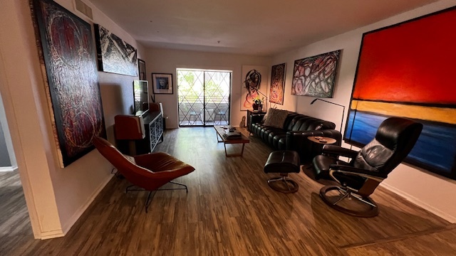 Living room with new vinyl plank flooring, motorized power shade, (no blinds) Very contemporary. - 7777 E Main St