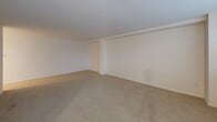 Located at 1209 W Wynnewood Rd in Wynnewood, PA, this well-appointed one-bedroom, one-bathroom unit offers a comfortable and functional layout across a single floor. The expansive living area is finished with neutral wall-to-wall carpeting and clean white walls, creating a bright and versatile canvas. A wall-mounted HVAC unit and baseboard heating ensure year-round comfort, while a window allows natural light to filter in. The updated kitchen is a standout feature, showcasing white shaker-style cabinetry, granite countertops, and a full suite of stainless steel appliances including a refrigerator, dishwasher, and range. Light tile flooring and a skylight overhead lend the kitchen an open, airy feel. An adjoining dining or living area benefits from a ceiling fan, dual windows with blinds, and additional baseboard heating. The generously sized bedroom offers plush carpeting and a double sliding-door closet, providing ample storage. The bathroom is clean and classic, featuring a full tiled tub-shower surround in crisp white. A hallway connects the rooms, completing this tidy and functional floor plan ideal for comfortable everyday living.