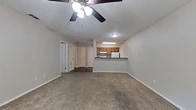 Located at 9124 Bernadette Ln in Shreveport, Louisiana, this single-story, one-bedroom, one-bathroom residence offers a practical and well-organized layout. The combined living room and kitchen area forms the heart of the home, with plush carpeting and a ceiling fan in the living space providing comfort. A raised breakfast bar visually separates the two areas while maintaining an open feel. The kitchen is designed for efficiency, featuring wood-tone cabinetry, dark countertops, hardwood-style flooring, a full suite of white appliances including a range and refrigerator, and ample upper and lower cabinet storage. A hallway connects the main living area to the private quarters of the home. The generously sized bedroom is carpeted and equipped with a ceiling fan, a window for natural light, and sliding glass doors fitted with vertical blinds that open to an outdoor balcony or walkway. The bedroom also provides direct access to a dedicated walk-in closet outfitted with multiple shelving units and a clothing rod, offering substantial storage capacity. The full bathroom includes a combined tub and shower with clean white surround panels. Throughout the residence, a neutral color palette creates a cohesive and functional living environment.