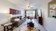 Located in Orlando, FL, this single-floor, two-bedroom, two-bathroom residence offers a well-organized layout designed for comfortable everyday living. A tiled entrance hallway welcomes you in, leading to the open-concept living, dining, and kitchen area at the heart of the home. The living room features plush carpeting, a ceiling fan, and a large window that draws in natural light and outdoor views. Adjacent to it, the dining area accommodates a full dining set and sits next to a convenient pantry with built-in shelving. The kitchen is equipped with wood-toned cabinetry, a gas range, a refrigerator, a double sink, and hardwood-style flooring, along with a breakfast bar with barstool seating. The primary bedroom offers carpet flooring, a ceiling fan, a generous walk-in closet with wire shelving, and a large window overlooking greenery outside. The second bedroom also features carpet, a ceiling fan, and direct access to a bathroom. Both bathrooms include a shower-tub combination with white tile surround. A dedicated in-unit laundry room with side-by-side washer and dryer and overhead shelving adds everyday practicality. Three closets throughout provide ample storage across the entire residence.