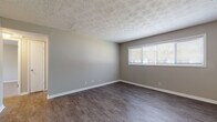 This single-floor unit offers a practical and well-organized layout with a variety of updated finishes throughout. The kitchen serves as a functional highlight, featuring crisp white shaker-style cabinetry, granite-look countertops, a subway tile backsplash, and a full suite of stainless steel appliances including a range, dishwasher, and refrigerator. A sliding glass door with vertical blinds allows natural light to fill the space and provides outdoor access.

The living areas feature durable hard surface flooring in a warm wood-tone finish, complemented by neutral gray walls and white baseboards. A textured ceiling adds visual interest in the main living space. The bedrooms are carpeted for comfort and each includes wide windows with blinds that bring in ample natural light. Ceiling fans with integrated lighting are present in multiple bedrooms, aiding in ventilation and climate control.

The bathroom is clean and functional, offering a full tub-shower combination with tile surround, a window for natural light, white vanity cabinetry, and hard surface flooring. Throughout the unit, the neutral color palette and updated materials create a cohesive, move-in-ready atmosphere suited for everyday living.