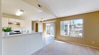 Located at 1904 College Blvd in Oceanside, California, this single-floor unit offers a practical and comfortable layout designed for everyday living. The open living and dining area is bright and airy, featuring soft carpet flooring, a ceiling fan, and a textured ceiling. Large sliding glass doors and a wide window flood the space with natural light while providing views of the surrounding outdoor balcony area, creating an inviting and open atmosphere.

The galley-style kitchen is efficiently designed with ample white cabinetry, light granite-look countertops, wood-look plank flooring, and a full suite of white appliances including a gas range, dishwasher, and refrigerator. A peninsula counter connects the kitchen to the living area, offering added functionality and a natural flow between spaces.

The bedroom is generously sized with plush carpet flooring and features dual sliding-door closets, providing substantial storage. The warm, neutral wall tones carry throughout the unit, contributing to a cohesive and calming aesthetic.

The bathroom is accessed via a dedicated hallway and includes wood-look plank flooring, a vanity with storage, and a shower-tub combination. Overall, this single-level unit combines practical design with comfortable finishes in a well-located Oceanside community.