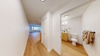 This 390-square-foot apartment in Seattle offers a well-designed living space that maximizes functionality. The open-concept layout combines the kitchen and living area, creating a sense of spaciousness. The modern kitchen features a mix of light wood and white cabinetry, stainless steel appliances, and ample counter space. A large window in the living area provides natural light and city views.

The bathroom showcases a contemporary design with a wood vanity, white countertop, and a shower/tub combination with sleek black fixtures. Throughout the apartment, warm wood flooring adds a touch of elegance and continuity.

The apartment's efficient design includes built-in storage solutions and minimalist finishes, making it ideal for urban living. The neutral color palette and clean lines create a fresh, contemporary ambiance. Despite its compact size, the thoughtful layout and use of space make this apartment feel larger and more open than its square footage might suggest.