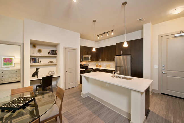 Open-concept gourmet kitchens with stainless steel appliances, granite slab countertops, custom cabinentry, and natural stone backsplash - Windsor at West University