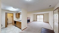 Located at 171 Applegrove St NE in North Canton, Ohio, this single-floor, two-bedroom, two-bathroom home offers a practical and comfortable layout. The open-concept living and dining area is a highlight, anchored by a wood-trimmed fireplace and sliding glass doors that lead to a private patio, filling the space with natural light and providing easy outdoor access. The adjacent kitchen features warm oak cabinetry, a double sink, and tile flooring, with a half-wall partition that maintains a sense of openness while defining the cooking space.

Both bedrooms are carpeted and finished with warm neutral tones, wood-trimmed windows, and rich baseboards. The spacious primary bedroom includes a dedicated closet with bifold doors, while the second bedroom is equally well-sized with its own window view. Each bedroom benefits from its own access to the hallways, which connect the private and shared areas of the home efficiently.

The two full bathrooms are finished with tile flooring and warm oak vanities. One features a walk-in shower, while the other includes a full soaking tub. Three closets throughout the home provide ample storage. A utility room and a dedicated entrance complete this well-organized, single-level floor plan.