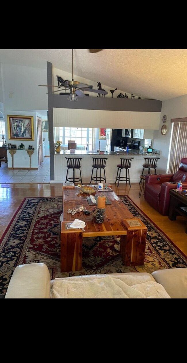 Vista de la sala de estar mirando hacia la cocina y la isla que tiene luces tenues. - 7639 Wells Ct