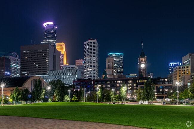 The Minneapolis skyline glows above the Downtown East green space known as The Commons.