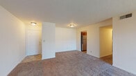 This single-floor residence at Plaza Square offers a practical and comfortable layout designed for everyday living. The spacious living area is finished with neutral-toned wall-to-wall carpeting and features a textured ceiling with flush-mount lighting. A sliding glass door floods the room with natural light and provides access to the outdoors, while a dedicated entryway with a paneled front door offers a clear sense of arrival.

The kitchen is well-appointed with warm oak cabinetry offering generous upper and lower storage, stone-toned countertops, tile flooring, and stainless steel appliances including a range, refrigerator, and dishwasher. The layout allows for efficient movement and connects seamlessly to the rest of the unit.

The bedrooms are carpeted and bright, each featuring windows fitted with blinds that allow for natural light and privacy. The rooms offer versatile layouts suitable for a range of furniture configurations. The bathroom is finished with tile flooring, a vanity with wood cabinetry, and clean white fixtures. A closet adjacent to the bathroom provides convenient built-in shelving for additional storage. Overall, the unit presents a clean, functional, and well-maintained living environment.