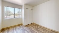 Located at 3985 N Stone Ave in Tucson, AZ, this 2-bedroom, 2-bathroom unit offers a compact and efficiently designed single-floor layout. Wood-look plank flooring runs consistently throughout the entire unit, lending a cohesive and clean aesthetic to every room. The kitchen features warm honey-toned cabinetry, white appliances including a range and refrigerator, a double-basin sink, and overhead lighting, making it a fully functional cooking space. Both bedrooms are bright and simply designed, each featuring sliding-door closets for storage and windows that allow natural light to filter in. The primary bedroom offers a comfortable footprint well-suited for standard bedroom furniture. The two bathrooms are clean and straightforward in design — one includes a shower-tub combination with white tile surround and a vanity with warm wood cabinetry, while the second bathroom features a walk-in shower and a towel bar. White walls throughout the unit create a neutral, move-in-ready canvas. The overall layout is practical and easy to navigate, with a no-frills design that prioritizes functionality and efficient use of space.