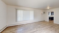Located at 8301 16 1/2 Mile Rd in Sterling Heights, MI, this 2-bedroom, 2-bathroom unit offers a well-organized single-floor layout designed for comfortable everyday living. Light wood-look flooring flows consistently throughout the space, creating a clean, cohesive aesthetic. The living area is generously sized, featuring a large window with vertical blinds that allow for ample natural light, a wall-mounted air conditioning unit, and baseboard heating. An exposed brick accent wall adds a subtle textural detail to the room. The kitchen is equipped with rich, dark-stained cabinetry, granite-style countertops, a stainless steel double sink, and a full-size refrigerator, offering both style and functionality. Both bedrooms are well-proportioned, each featuring ceiling fans, vertical blinds or window blinds for light control, baseboard heating, and generous closet space with double bi-fold doors. The two bathrooms continue the granite countertop theme, complemented by dark vanity cabinetry. One bathroom includes a full tub-shower combination with white tile surround. A hallway connects the living spaces efficiently, completing this thoughtfully laid-out home.