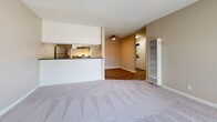 Located in Hacienda Heights, CA, this single-story, one-bedroom, two-bathroom residence offers a thoughtfully arranged floor plan designed to maximize functionality. The open-concept living area features plush wall-to-wall carpeting, neutral warm-toned walls, and a textured ceiling. A large sliding glass door fitted with vertical blinds floods the space with natural light while providing direct outdoor views, and a wall-mounted air conditioning unit ensures year-round comfort. The living room flows seamlessly into a dedicated dining area, creating a cohesive entertaining space. The kitchen features white cabinetry, gray countertops, a stainless steel sink, a dishwasher, and a stainless steel refrigerator, all set above wood-look hard flooring that extends through the dining area. A ceiling fan overhead adds a practical touch. The private bedroom is generously sized with soft carpeting, vertical blinds on a sliding window, and ample natural light. Two closets provide solid storage solutions throughout the unit. A convenient in-unit laundry area houses a stacked washer and dryer. Two bathrooms complete the layout, offering added convenience for residents and guests alike.