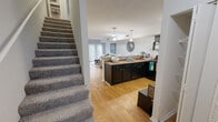 Located at 5201 Western Ave in Knoxville, TN, this two-story home offers 3 bedrooms and 2 bathrooms thoughtfully distributed across two equally sized floors. The main level features an open-concept layout where the kitchen flows seamlessly into the living and dining areas. The kitchen is appointed with dark cabinetry, granite-style countertops, stainless steel appliances, and a peninsula with pendant lighting — ideal for both cooking and casual dining. The adjacent living room is bright and welcoming, with hardwood flooring, a sliding glass door that opens to an outdoor patio, and ample natural light. A convenient full bathroom with dark vanity cabinetry and granite countertops is also found on this level. A carpeted staircase leads to the upper floor, where the bedrooms are located. Each bedroom features plush carpeting, ceiling fans, and natural light from well-placed windows. The primary bedroom is generously sized, offering two closets — including a walk-in — providing excellent storage. The upper-level bathroom mirrors the design of the lower, with a granite-topped vanity and a shower/tub combination. Throughout the home, a neutral color palette and consistent finishes create a cohesive and comfortable living environment.