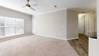 Located along U.S. 98 in Pensacola, Florida, this single-story 2-bedroom, 2-bathroom residence offers a well-organized layout designed for comfortable living. The galley-style kitchen is a standout feature, showcasing white cabinetry, dark granite-style countertops, black appliances including a refrigerator, range, and dishwasher, and a stainless steel sink — all set atop durable wood-look plank flooring. A curved breakfast bar peninsula connects the kitchen to the open living area, which transitions to plush neutral carpeting. The living space benefits from natural light and is finished with crown molding and a ceiling fan with light kit. Both bedrooms are generously proportioned, carpeted, and equipped with ceiling fans. Each room features large windows with blinds that allow ample natural light. The primary bedroom includes access to a dedicated closet. The secondary bedroom is similarly sized with its own closet access. A hallway connects the main living areas to the bedrooms and bathrooms. Both bathrooms feature tub/shower combinations with white tile surrounds and chrome fixtures, with one bathroom including dark countertop vanity and wood-look flooring. Additional storage is provided by a pantry and multiple closets throughout.