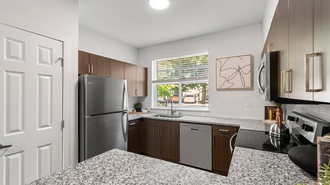 Los diseños modernos de concepto abierto crean una transición fluida entre la cocina y la sala de estar. - The Timbers at Issaquah Ridge