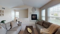 Located at Spring Meadow Drive in Buffalo, NY, this single-floor residence offers a well-organized and comfortable layout designed for everyday living. The living room is a welcoming centerpiece, highlighted by vaulted ceilings, a tile-surround fireplace, and multiple windows that fill the space with natural light. An open-concept design connects the living area to the kitchen, which features warm honey-toned wood cabinetry, granite countertops, stainless steel appliances, and a peninsula with bar seating — ideal for casual dining or entertaining. Hardwood-style flooring runs through the kitchen and dining areas, while the dining room benefits from a ceiling fan, sheer-curtained windows, and a private exterior door providing direct outdoor access. The bedrooms are carpeted and thoughtfully sized, each receiving natural light through windows with blinds. One bedroom features a classic white wood bed frame and soft neutral tones, while another offers a cozy, well-lit atmosphere. The bathroom is clean and functional, with a shower-tub combination. Throughout, the unit maintains a warm, neutral color palette with textured ceilings, creating a cohesive and inviting residential environment.