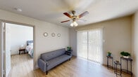 Located in Austin, TX, this one-bedroom, one-bathroom unit offers a practical and well-organized single-floor layout. Light wood laminate flooring runs throughout the space, creating a cohesive and clean aesthetic. The living room is bright and welcoming, featuring a ceiling fan with light fixture, a large sliding glass door dressed with vertical blinds that allows natural light to fill the room, and direct access to the outdoors. The kitchen is efficiently designed with dark upper cabinetry, stainless steel appliances including a full-size refrigerator and range, granite-style countertops, and a window that brings in additional natural light. The bedroom is a comfortable, well-proportioned room with its own ceiling fan, a window with blinds offering natural light and outdoor views, and light wood flooring. A dedicated walk-in closet with built-in shelving provides ample storage. The bathroom features tile walls and a shower-tub combination. Throughout the unit, neutral wall tones and consistent flooring choices contribute to a calm, functional living environment suited for everyday comfort.