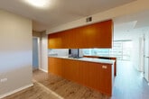 Located at 9739 Woods Dr in Skokie, IL, this well-appointed two-bedroom, two-bathroom residence offers a thoughtfully designed single-level floor plan with generous living space. The open-concept kitchen and living area serves as the heart of the home, featuring warm wood cabinetry, granite countertops, a gas cooktop, and a seamlessly integrated peninsula. Light hardwood flooring runs throughout the main living areas, complementing the clean, modern aesthetic. Floor-to-ceiling windows flood the living room with natural light and provide sweeping views of the surrounding urban skyline, creating a bright and airy atmosphere. The spacious primary bedroom features plush carpeting and its own large window with outdoor views. The second bedroom is equally comfortable with soft carpet flooring. Both bathrooms are well-finished; the primary bath offers a dual-sink vanity with granite countertops and rich wood cabinetry, while the second bathroom features full tile surround and a soaking tub. A dedicated laundry room and an impressive seven closets throughout the unit ensure exceptional storage. The overall ambiance is modern and functional, balancing contemporary finishes with practical livability in a high-rise setting.