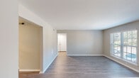 Located at 2421 Gazebo Dr in Morrisville, NC, this single-floor unit offers a clean, contemporary interior finished with neutral tones throughout. The open living area is anchored by durable wood-style laminate flooring and lined with crisp white baseboards, creating a bright and cohesive aesthetic. Natural light enters through multiple windows fitted with horizontal blinds, contributing to an airy atmosphere across the main living spaces.

The kitchen is well-appointed with white shaker-style cabinetry, light countertops, and a full suite of stainless steel appliances, including a range, microwave, refrigerator, and dishwasher. A single-basin sink and subtle tile backsplash complete the functional layout.

The bedrooms feature plush wall-to-wall carpeting and generous windows that allow natural light and outdoor views. Each room maintains the same neutral color palette seen throughout the unit, lending a consistent, move-in-ready feel.

The bathrooms are finished with white vanity cabinetry, light countertops, and wood-style flooring. One bathroom includes a full tub-shower combination with white tile surround and brushed nickel fixtures, while another features a vanity with a large mirror and modern hardware. Overall, the space presents a clean, updated interior well-suited for comfortable everyday living.