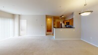Located at 20404 Honey Crisp Ln in Germantown, Maryland, this single-floor residence offers a well-designed layout with a cohesive blend of comfort and functionality. The spacious living room serves as the heart of the home, anchored by a classic fireplace with a clean white surround and black insert. Plush wall-to-wall carpeting and large sliding glass doors with vertical blinds allow ample natural light to fill the room, creating a bright and welcoming atmosphere. The open-concept layout connects the living area seamlessly to the kitchen, which is accessed via a peninsula-style breakfast bar. The kitchen is outfitted with warm honey-toned cabinetry, dark granite countertops, hardwood flooring, and a full suite of stainless steel appliances including a gas range with over-the-range microwave and a French door refrigerator. The bedrooms are generously sized, featuring soft carpeting and neutral-toned walls; one bedroom benefits from a large window with an outdoor view, filling the room with natural light. The bathrooms are finished with warm wood vanities, white countertops, and light tile flooring. The full bathroom includes a tiled tub-shower combination, while the primary bath features a dual-sink vanity with ample storage and mirror lighting.