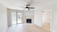Located at 1101 N Georgetown St in Round Rock, TX, this 2-bedroom, 1-bathroom home offers a clean, modern aesthetic throughout its single-floor layout. Light wood flooring flows seamlessly across all rooms, creating a bright and cohesive feel.

The open living room serves as the heart of the home, anchored by a tile-surround fireplace and a ceiling fan with light fixture. A sliding glass door fills the space with natural light and provides direct access to an outdoor patio area with exterior views.

The kitchen is thoughtfully updated, featuring taupe cabinetry, a white countertop with an integrated cooktop, a decorative tile backsplash, and stainless steel appliances including a refrigerator, dishwasher, and over-the-range microwave.

The spacious primary bedroom includes a ceiling fan, a dedicated closet, and connects to additional rooms via a hallway. The second bedroom is well-proportioned, also featuring a ceiling fan and a window with natural light.

The bathroom is finished with floor-to-ceiling large-format marble-look tile surrounding a soaking tub and shower combination, complemented by matte black fixtures for a contemporary touch. Clean white walls and bright finishes throughout give the entire home a fresh, move-in-ready appearance.