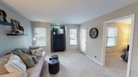 Located at 107 Bent Tree Ln in Schaumburg, Illinois, this single-floor home offers a well-organized and thoughtfully designed layout. The living room is a welcoming space featuring soft carpeting, neutral gray walls, and multiple windows dressed with white plantation shutters that invite generous natural light. Decorative floating shelves and direct access to the outdoors through a side door add both character and convenience to the area.

The kitchen is efficiently laid out with white shaker-style cabinetry, bright white countertops, and durable wood-look flooring. Stainless steel appliances — including a range with microwave above and a full-size refrigerator — provide a modern, functional cooking environment. Recessed lighting keeps the space well-lit throughout.

The bedroom is a calm retreat with plush carpeting, soft neutral tones, and a large window that allows ample natural light. It connects to a spacious walk-in closet outfitted with wire shelving, offering generous storage capacity.

The bathroom is clean and contemporary, featuring a wide single-sink vanity with white cabinetry, a large mirror, light wood-look flooring, and a shower-tub combination. Decorative wall shelves add a subtle personal touch. Overall, the home presents a cohesive, neutral palette with comfortable finishes throughout.