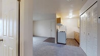 Located at 4429 Irish Hills Dr in South Bend, Indiana, this single-floor unit offers a straightforward, functional layout designed for comfortable everyday living. The floor plan flows efficiently between the main living area, kitchen, bedroom, and bathroom, making practical use of the available space.

The living area is carpeted and open, featuring a wall-mounted air conditioning unit and a sliding glass door fitted with vertical blinds that allows natural light to enter and provides a view of the surrounding exterior. The transition from carpet to hard-surface flooring marks the boundary between the living space and the kitchen entry.

The kitchen is galley-style with light wood cabinetry, a gas range with overhead ventilation hood, a full-size refrigerator, and a double-basin sink with ample counter space. The hard-surface wood-look flooring runs throughout the kitchen, lending a clean, easy-to-maintain finish.

The bedroom features neutral carpet, two louvered bi-fold closets offering generous storage, a window that brings in natural light, and direct access to the full bathroom. The bathroom includes a single-sink vanity with light wood cabinetry, a toilet, and a tiled shower-tub combination with chrome fixtures and a mirrored medicine cabinet.