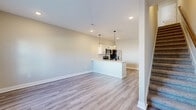 Located on Needmore Rd in Clarksville, Tennessee, this two-story home offers a thoughtfully arranged layout spread evenly across both floors. The main level features an open-concept kitchen and living area with light wood-look luxury vinyl plank flooring throughout. The kitchen is outfitted with crisp white shaker cabinetry, a peninsula with pendant lighting, a undermount sink with a matte black faucet, and a full suite of stainless steel appliances including a refrigerator with ice maker, range, microwave, and dishwasher. The living area flows naturally from the kitchen, creating a bright, welcoming space ideal for everyday living. A dedicated laundry room with washer and dryer hookups adds convenient functionality to the main floor. Upstairs, three bedrooms are carpeted for comfort, each receiving natural light through windows with exterior views. The primary bedroom is generously sized and includes its own closet. The home features three full bathrooms, each finished with white cabinetry, black hardware accents, tub-shower combinations, and wood-look vinyl flooring. With seven closets distributed throughout, storage is plentiful. The clean, neutral color palette and modern finishes give the entire home a fresh, move-in-ready feel.
