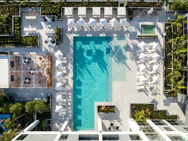 Indulge in the Miami sun on our expansive pool deck, offering luxury seating and a poolside bar - Cascade Link at Douglas Apartments
