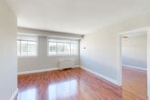 Located at 5323 Connecticut Ave NW in Washington, DC's Chevy Chase neighborhood, this one-bedroom, one-bathroom unit offers a well-organized layout across a single floor. Rich, warm hardwood-style flooring runs throughout the living spaces, reflecting natural light and lending a polished look to every room.

The combined living and dining area is the heart of the unit, featuring multiple windows that fill the space with abundant natural light and provide views of the surrounding neighborhood. A baseboard heating unit keeps the space comfortable year-round, and clean gray walls complement the bright white trim throughout.

The kitchen is thoughtfully appointed with white shaker cabinetry, granite countertops, a subway tile backsplash, and stainless steel appliances including a gas range, microwave, and refrigerator. Light tile flooring and a modern pull-down faucet complete the functional yet stylish space.

The bedroom offers a comfortable footprint with a ceiling fan, a sliding-door closet, and direct access to the full bathroom. The bathroom features a glass-enclosed shower, offering a clean and practical design. Neutral gray tones and consistent hardwood-style flooring create a cohesive aesthetic throughout the entire unit.