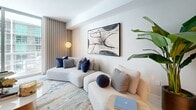 Located on the 38th floor at 77 SE 5th St in Miami's Brickell neighborhood, this thoughtfully designed one-bedroom, one-bathroom residence offers a refined urban living experience across a well-appointed single floor. The open-concept layout connects the living room, kitchen, and hallway seamlessly, creating an airy and cohesive flow throughout.

The kitchen is a standout, featuring sleek light wood cabinetry, white marble-veined stone backsplash and countertops, under-cabinet LED lighting, and gold-toned fixtures — including a refined brass gooseneck faucet — that add a touch of warmth and luxury.

The living room is elegantly appointed with a textured blue-grey accent wall, light hardwood-style flooring, and access to a private balcony with city views. The spacious primary bedroom features bold blue-and-white patterned wallpaper on an accent wall, floor-to-ceiling windows, and ample natural light, creating a bright and stylish retreat.

The bathroom showcases a floating double-sink vanity in light wood, a large gold-framed mirror, and a clean white quartz countertop, maintaining the cohesive modern aesthetic found throughout the residence. A dedicated closet and hallway complete the well-organized floor plan, making this a polished and functional Miami high-rise home.