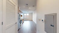 Located at 808 Chapel Street in the heart of New Haven, CT, this thoughtfully designed single-floor unit offers a clean, modern aesthetic with an efficient and functional layout. Light wood-tone luxury vinyl plank flooring runs throughout, tying together the open-plan living space and providing a warm contrast to the crisp white walls and ceilings.

The kitchen is a standout feature, outfitted with flat-front light wood cabinetry extending to the ceiling for ample storage, white quartz countertops, and a full suite of stainless steel appliances including a refrigerator, electric range, over-the-range microwave, and dishwasher. Track lighting overhead ensures the kitchen is well-lit for both cooking and entertaining.

The kitchen flows seamlessly into the open dining area, which benefits from a large window that draws in natural light and provides views of the surrounding streetscape. The open layout creates a versatile space adaptable to various furniture arrangements.

The bathroom continues the modern design language, featuring a wood-grain vanity with a white undermount sink, black matte hardware, a large mirror, wood-look tile flooring, and accessibility-friendly grab bars. The space is clean, bright, and well-appointed. Overall, the unit presents a contemporary urban living environment with quality finishes throughout.