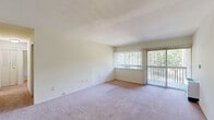 This two-bedroom, two-bathroom residence in Ypsilanti, Michigan offers a practical and well-organized single-floor layout. The combined kitchen and living room forms the heart of the home, with the living area featuring large windows and a sliding glass door that flood the space with natural light and provide views of the surrounding greenery. Soft carpeting runs throughout the living area and both bedrooms, lending a warm, comfortable feel to the interior.

The kitchen is equipped with ample upper and lower cabinetry in a classic white finish, a double-basin sink, laminate countertops, and durable tile flooring — providing a functional workspace for everyday use.

Both bedrooms are generously proportioned, with the primary bedroom offering notable space. Each room features vertical blinds over the windows, ceiling fans with light fixtures, and closet storage. The primary bedroom benefits from a dedicated walk-in closet with built-in shelving on multiple levels, maximizing storage capacity.

The two bathrooms mirror each other in design, each featuring mosaic tile flooring, a vanity with cabinetry, and a tub-shower combination with white tile surrounds, maintaining a clean and consistent aesthetic throughout. Neutral wall tones and cream-colored finishes create a cohesive, move-in-ready atmosphere throughout the entire residence.