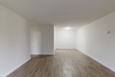 This 2-bedroom, 1-bathroom apartment offers a practical and comfortable single-floor layout designed to maximize livability. The spacious living room is finished with warm wood-look laminate flooring and bright white walls, creating a clean, open atmosphere. A large sliding glass door fills the room with natural light and provides direct access to a private balcony overlooking mature trees, bringing a sense of the outdoors inside.

The kitchen is equipped with a stainless steel range, dark granite-style countertops, white cabinetry, and a classic subway tile backsplash. An adjacent pantry offers additional storage. The hallway connects the living areas to the private quarters, where both bedrooms feature the same wood-look flooring and neutral tones. The primary bedroom is generously sized, while the second bedroom includes a closet with built-in shelving and hanging rods. In total, three closets are distributed throughout the unit, providing ample storage.

The bathroom is outfitted with a full bathtub and shower combo, featuring clean white rectangular wall tiles with a timeless look. Textured ceilings are found in select rooms, adding a subtle design detail. Overall, the apartment presents a tidy, functional, and light-filled living environment.