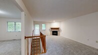 This two-bedroom, two-bathroom unit at 200 Lake Forest Blvd in Kalamazoo, Michigan spans two floors, offering a well-organized layout with comfortable living spaces throughout. The main level houses the kitchen and living room, while the upper floor contains the bedrooms and additional living area.

The upper-level living room is a welcoming, open space featuring plush carpeting, a tile-surround fireplace with a warm wood mantel, and windows that invite natural light. A wood-railed staircase connects the two floors. The kitchen on the main level is functionally equipped with warm oak cabinetry, white appliances including a refrigerator, electric range, and built-in microwave, and durable wood-look flooring. A large window brings in ample natural light.

The generously sized primary bedroom features soft carpeting and a wide closet with built-in shelving. The second bedroom is equally well-proportioned with carpet and bright window views of the surrounding greenery. Both bathrooms are finished with classic white hexagonal tile flooring, a vanity with wood cabinetry, and a bathtub. The space also includes a hallway and closet for added storage. Throughout, the neutral color palette and natural light create a clean, functional, and inviting atmosphere.