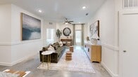 Located in Lake Charles, Louisiana, this thoughtfully designed 4-bedroom, 3-bathroom home offers a functional and stylish single-floor layout. The open-concept kitchen and dining area serves as the heart of the home, showcasing gray shaker-style cabinetry, granite countertops, a large center island with seating, pendant lighting, and a full suite of stainless steel appliances. Polished concrete floors flow throughout the main living areas, lending a modern, low-maintenance aesthetic. The living room is bright and welcoming, featuring a ceiling fan, recessed lighting, wainscoting details, and access to a private balcony. The dining space benefits from natural light streaming through large windows dressed with decorative curtains. Each of the four bedrooms is well-proportioned, with the primary bedroom offering dedicated closet space and natural light. With seven closets total, storage is abundant throughout. The three bathrooms are finished with granite-topped vanities and gray cabinetry consistent with the home's overall design palette. A dedicated laundry room and a central hallway complete the layout, making this home as practical as it is polished.