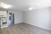 Located at 2580 Wild Pines Lane in Naples, Florida, this one-bedroom, one-bathroom unit offers a practical and well-organized layout across a single floor. Light wood-style flooring runs throughout the space, complementing the soft gray-toned walls and white trim for a clean, neutral aesthetic.

The open-concept main area seamlessly combines the kitchen, dining, and living spaces. The kitchen is outfitted with white cabinetry, ample upper and lower storage, a full-size refrigerator, an electric range, built-in microwave, and a single-basin sink — all illuminated by a ceiling-mounted light fixture. A ceiling fan with a light kit serves the living area, which also benefits from a sliding glass door that leads to a private patio, allowing natural light to filter into the space.

The bedroom is a comfortable, well-proportioned room featuring its own ceiling fan and two closets, offering generous storage. The bathroom includes a tub-shower combination with white tile surround, maintaining the unit's consistent clean and functional design. Hallway access connects the bedroom to the main living area efficiently.

This unit provides a straightforward, low-maintenance living environment well-suited for those seeking a practical residence in the Naples, FL area.
