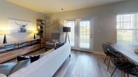 Located at 1600 Lake Seymour Dr in Middletown, Delaware, this single-floor residence offers a well-designed layout with a cohesive blend of modern finishes and comfortable living spaces. The open-concept living area is anchored by durable hardwood-style flooring and features a sliding glass door that fills the room with natural light while providing outdoor access. The kitchen is outfitted with rich dark cabinetry, granite countertops, a breakfast bar, and a full suite of stainless steel appliances, including a gas range, built-in microwave, and refrigerator — all illuminated by sleek track lighting overhead. The primary bedroom is generously proportioned, with large windows, plush carpeting, and direct access to a private en-suite bathroom. The en-suite features a dual-sink vanity with dark wood cabinetry, a large mirror with overhead lighting, and light tile flooring. Additional bedrooms offer comfortable dimensions, carpeted floors, and ample natural light through well-sized windows. A secondary full bathroom includes a tub-shower combination and clean tile flooring. Neutral tones throughout the home create a calm, inviting ambiance that suits a variety of design preferences, making this residence a practical and attractive option in the Middletown, DE area.