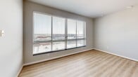 Located at 3410 West Clay Street in Richmond, Virginia, this one-bedroom, one-bathroom unit offers a well-organized layout across a single floor. Light wood-style flooring flows throughout the main living areas, complementing the clean, neutral color palette of white walls and modern trim.

The living room features a distinctive pass-through window connecting to the kitchen, creating an open visual link between the two spaces. The galley-style kitchen is efficiently designed with white shaker cabinets, dark granite countertops, a subway tile backsplash, a stainless steel undermount sink, and a full suite of stainless steel appliances.

The bedroom is a comfortable size, highlighted by a large, multi-panel window fitted with horizontal blinds that frames an elevated city view of the surrounding Richmond neighborhood. The room is carpeted and includes two closets — one walk-in and one double-door — providing ample storage.

The bathroom is finished with marble-look tile flooring, a dark granite vanity countertop with white cabinetry, white subway-tiled tub/shower combination, and a frosted glass entry door that adds a modern touch. The overall ambiance of the unit is clean, contemporary, and functional, making efficient use of its compact footprint.