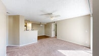 Located at 3440 N Goldenrod Rd in Winter Park, Florida, this three-bedroom, two-bathroom residence offers a well-organized single-floor layout designed for comfortable everyday living. The open-concept living area is bright and inviting, featuring plush carpeting, neutral warm-toned walls, a ceiling fan with light fixture, and a textured ceiling. Large windows with blinds allow abundant natural light to fill the space. The kitchen is a functional highlight, outfitted with white cabinetry, granite-style countertops, a subway tile backsplash, stainless steel appliances including a refrigerator, electric range, and dishwasher, plus a breakfast bar that connects seamlessly to the living area. Track lighting adds a modern touch overhead. The bedrooms are carpeted and tranquil, each offering generous proportions and ample closet access — with four closets total throughout the unit. The two bathrooms are clean and well-appointed; one features a wide vanity with granite-look countertops and wood-look flooring, while the other includes a tiled shower-tub combo. A dedicated laundry room houses a full-size washer and dryer. Wood-look flooring flows through the kitchen, hallways, and bathrooms, adding a cohesive, polished feel. A private balcony rounds out this practical and comfortable Winter Park home.