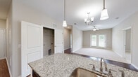 Located at 627 Legacy Ct in Greenville, NC, this well-appointed single-story home offers three bedrooms, two bathrooms, and a thoughtfully designed layout. The open-concept kitchen is a standout feature, showcasing white shaker cabinetry, granite countertops, stainless steel appliances, a central island with pendant lighting, and a walk-in pantry with wire shelving — all set atop rich hardwood-style flooring. A chandelier adds an elegant touch to the dining area, which flows seamlessly into the kitchen.

The living room is bright and inviting, with plush carpet, a ceiling fan, and French doors that frame outdoor views and fill the space with natural light. Each bedroom offers carpeted floors, neutral walls, and ample natural light through window blinds. The primary bedroom connects to a spacious walk-in closet with wire shelving systems, and an en-suite bathroom. Both bathrooms feature granite-topped vanities with white cabinetry, framed mirrors, hardwood-style flooring, and full tub-shower combinations. Additional closets throughout the home provide generous storage. The home's neutral color palette and consistent finishes create a clean, cohesive ambiance throughout.